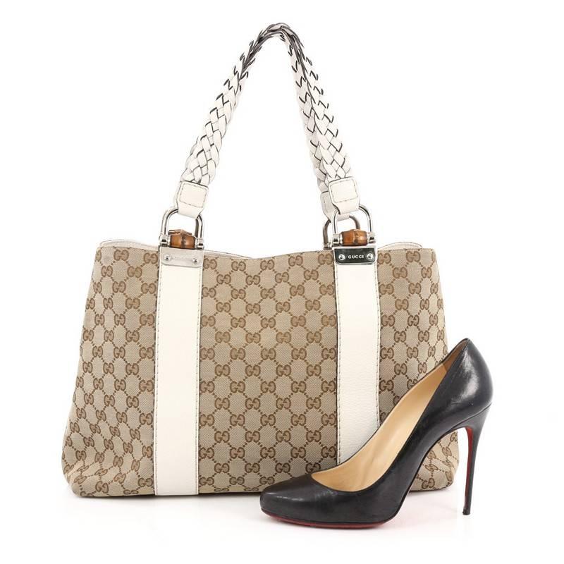 This authentic Gucci Bamboo Bar Tote GG Canvas Medium is a simple yet sophisticated daily bag for the on-the-go woman. Crafted from brown GG canvas, this beautiful and functional tote features braided dual strap handles with bamboo details, white