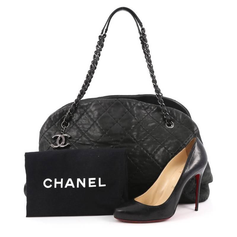 This authentic Chanel Just Mademoiselle Handbag Quilted Iridescent Leather Maxi showcases a sleek style that complements any look. Crafted from black iridescent leather in Chanel's iconic diamond quilted pattern, this oversized tote features a