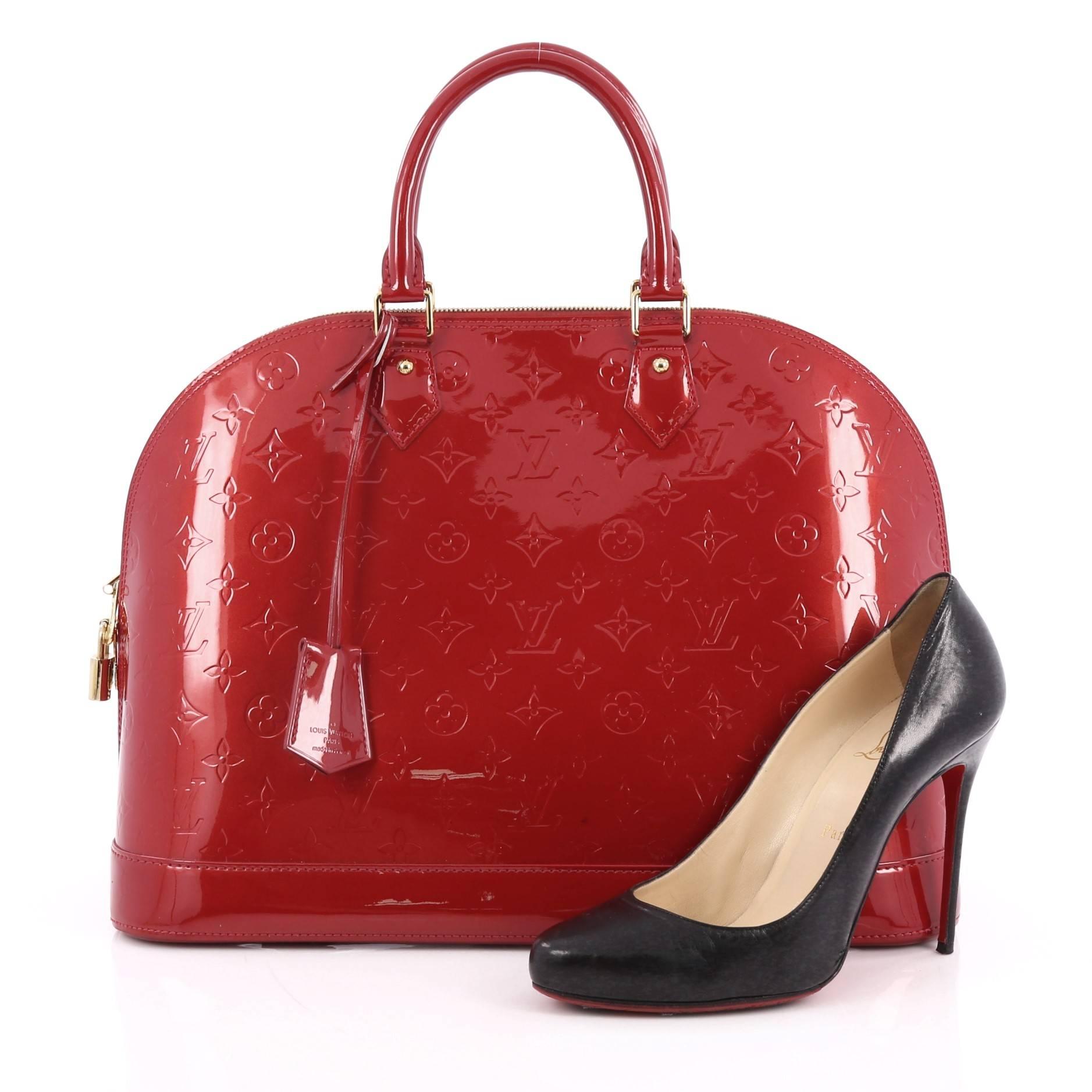 This authentic Louis Vuitton Alma Handbag Monogram Vernis GM is a fresh and elegant spin on a classic style that is perfect for all seasons. Crafted from Louis Vuitton's red monogram vernis, this dome-shaped satchel features dual-rolled handles,