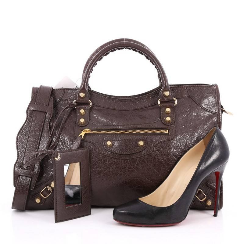 This authentic Balenciaga City Giant Studs Handbag Leather Medium is for the on-the-go fashionista. Constructed from carbon dark brown leather, this popular bag features dual braided woven tall handles, exterior front zip pocket, iconic Balenciaga