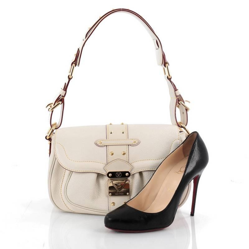 This authentic Louis Vuitton Suhali Le Confident Handbag Leather is a glamorous shoulder bag that adds a stylish touch to your look. Crafted from off-white suhali goatskin leather, this timeless bag features an adjustable wide leather belted