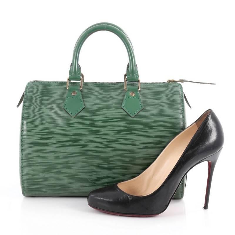 This authentic Louis Vuitton Speedy Handbag Epi Leather 25 is a timeless favorite of many. Crafted in borneo green epi leather, this bag features dual-rolled handles, subtle stamped LV logo, exterior side slip pocket and gold-tone hardware accents.