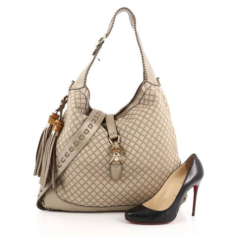 This authentic Gucci New Jackie Handbag Diamante Canvas Large is a must-have everyday hobo fit for the modern woman. Constructed from Gucci's light brown diamante canvas with gold leather trims, this modern reinterpretation of the Jackie bag
