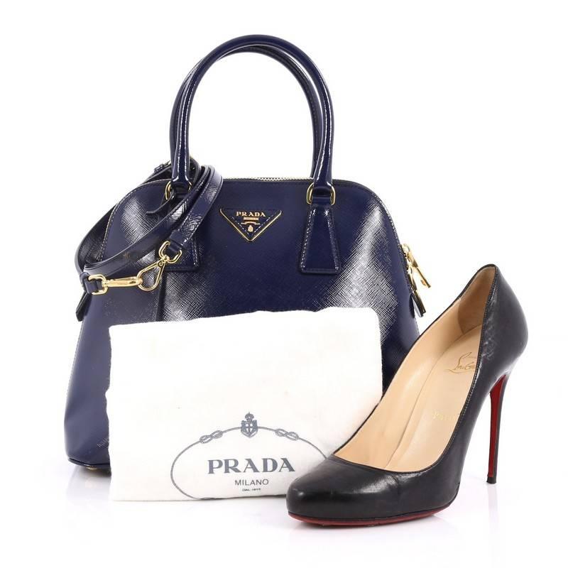 This authentic Prada Zip Around Convertible Dome Satchel Vernice Saffiano Leather North South is elegant in its simplicity and structure. Crafted in dark blue vernice saffiano leather, this sleek dome-shaped satchel features dual-rolled handles,