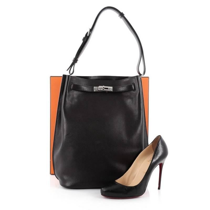 This authentic Hermes So Kelly Handbag Evergrain 26, first released in 2008, is an updated and modern reinterpretation of the Kelly Sport taking its distinct look to Hermes' classic kelly design. Crafted in black evergrain leather, this luxurious