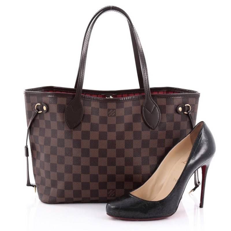 This authentic Louis Vuitton Neverfull NM Tote Damier PM is a popular and practical tote beloved by many. Constructed with Louis Vuitton's signature damier ebene coated canvas, this tote is spacious and structured without being bulky. The side laces