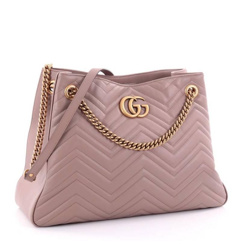 This authentic Gucci GG Marmont Chain Shoulder Bag Matelasse Leather is simple yet stylish in design. Crafted from beautiful taupe matelasse leather, this hobo features bronze chain strap with leather pads, iconic interlocking GG logo, and