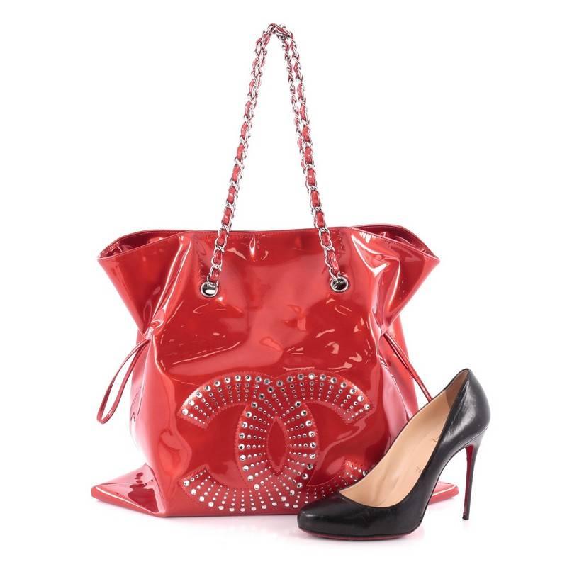 This authentic Chanel Bon Bon Tote Strass Embellished Patent Large from the brands Spring 2010 Collection is a modern design with subtle edge made for everyday use. Crafted from red patent leather, this no-fuss, stylish tote features an oversized