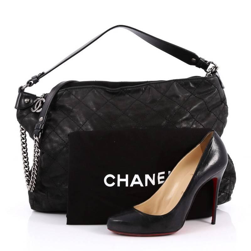 This authentic Chanel Coco Daily Hobo Quilted Iridescent Calfskin Large is a relaxed and versatile bag perfect for casual luxury. Crafted in black quilted iridescent calfskin leather, this bag features chain strap with leather shoulder pad, leather