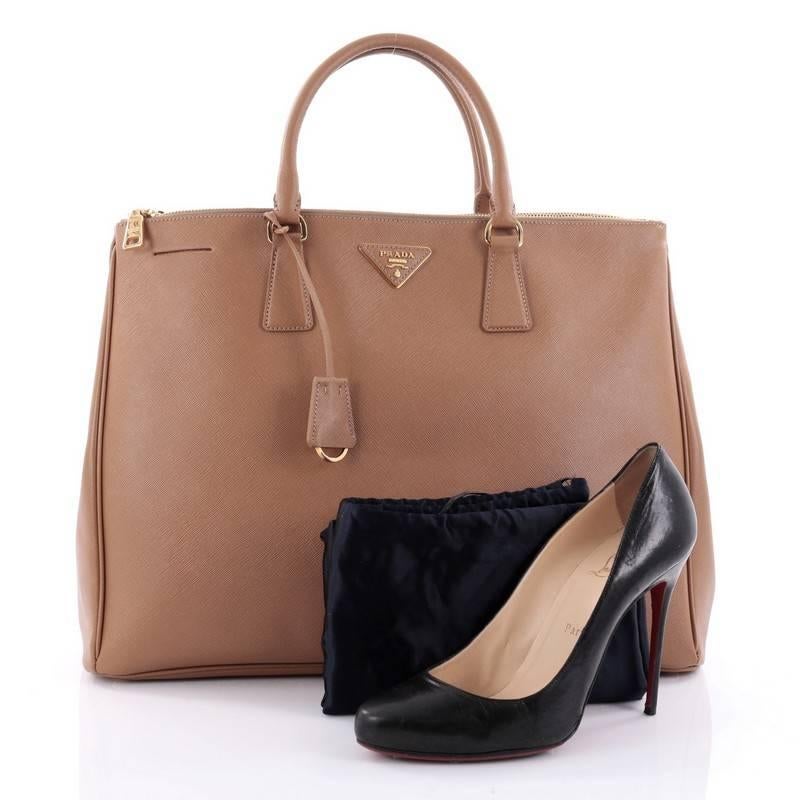 This authentic Prada Double Zip Lux Tote Saffiano Leather Large is the perfect bag to complete any outfit. Crafted from brown saffiano leather, this boxy tote features side snap buttons, raised Prada logo, dual-rolled leather handles and gold-tone
