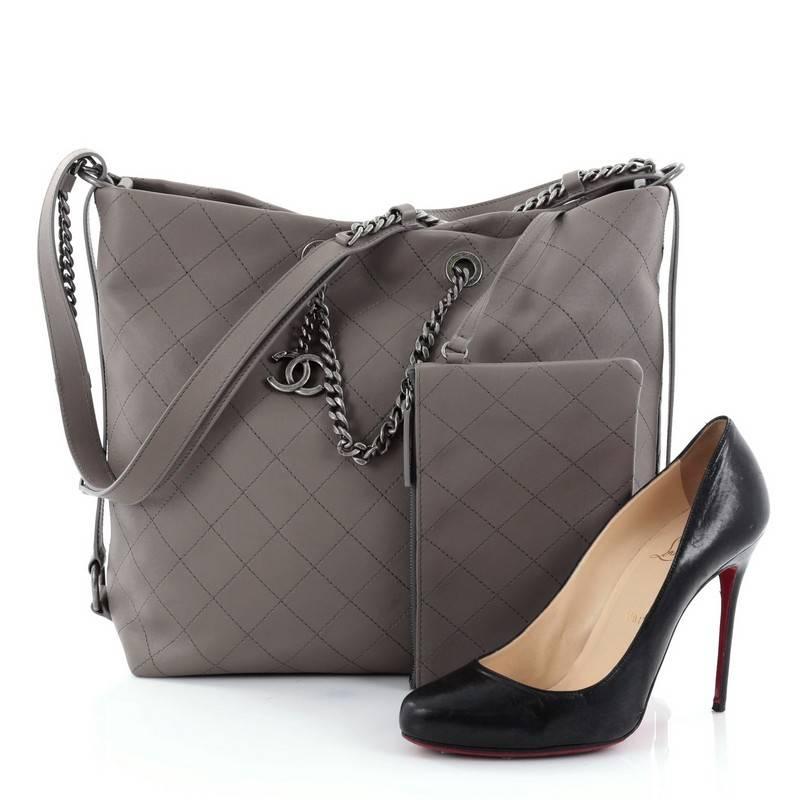 This authentic Chanel Messenger Strap Tote Quilted Calfskin Medium is a simple yet luxurious accessory, ideal for everyday use. Crafted in grey quilted calfskin leather, this chic bag features saged silver chain-link handles, leather shoulder strap