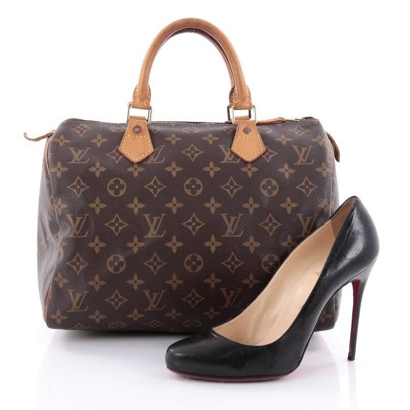 This authentic Louis Vuitton Speedy Handbag Monogram Canvas 30 is spacious and light, making it ideal to use everyday. Constructed in Louis Vuitton's classic brown monogram coated canvas, this iconic Speedy features dual-rolled leather handle,