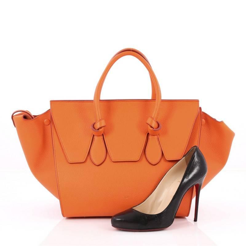 This authentic Celine Tie Knot Tote Grainy Leather Mini is an absolute must-have for serious fashionistas. Crafted from orange grainy leather, this boxy, chic tote features dual-rolled leather handles with signature knot accents, subtle stamped gold