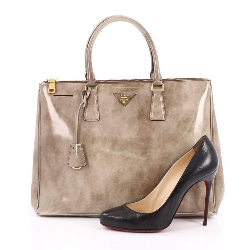 This authentic Prada Double Zip Lux Tote Spazzolato Leather Medium is the perfect bag to complete any outfit. Crafted from brown and beige spazzolato leather, this boxy tote features side snap buttons, raised Prada logo, dual-rolled leather handles