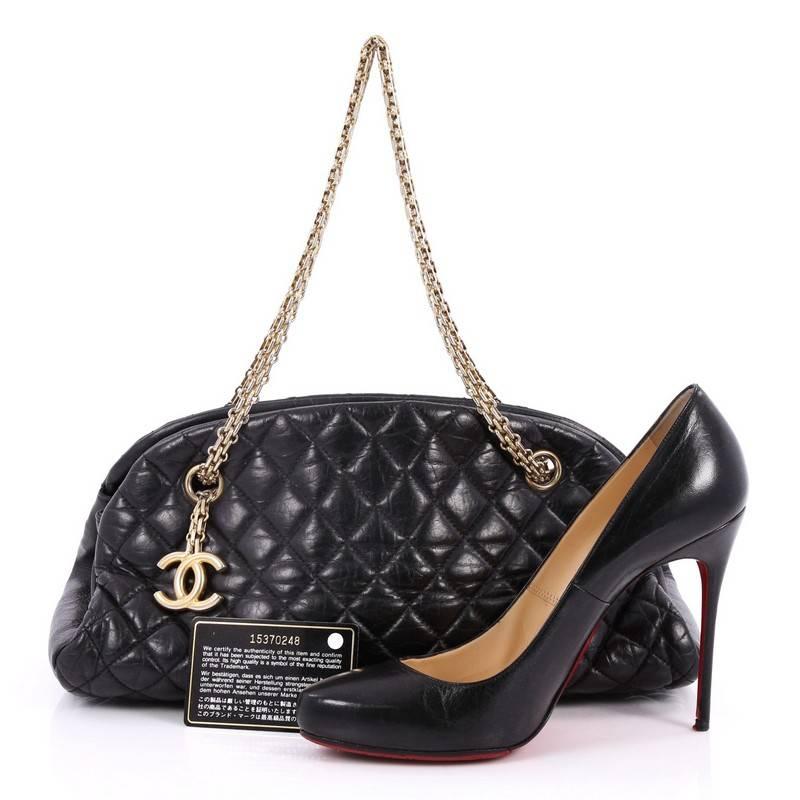 This authentic Chanel Just Mademoiselle Handbag Quilted Aged Calfskin Medium showcases a sleek style that complements any look. Crafted from beautiful black aged calfskin leather in Chanel's iconic diamond quilting pattern, this shell-like bag