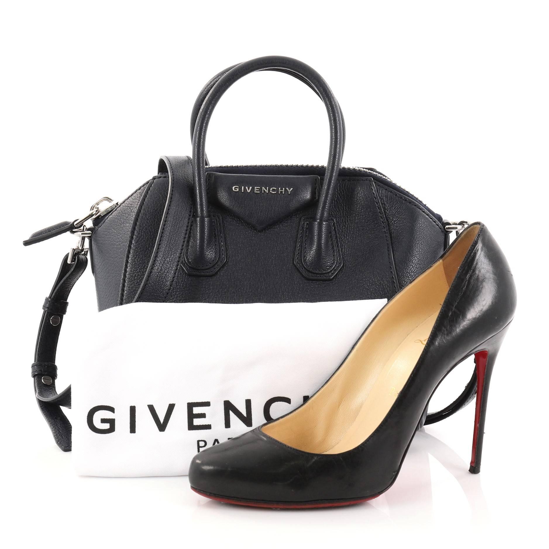 This authentic Givenchy Antigona Bag Leather Mini presents the brand's most iconic bag in a miniature version. Crafted from supple navy leather, this structured handle bag features the brand's signature envelope flap detail with silver Givenchy