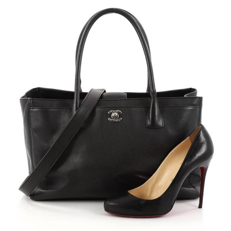 This authentic Chanel Cerf Executive Tote Leather Medium is an ideal everyday accessory for the modern woman. Crafted from classic black leather, this functional tote features dual-rolled tall handles, front pocket with CC turn-lock closure,