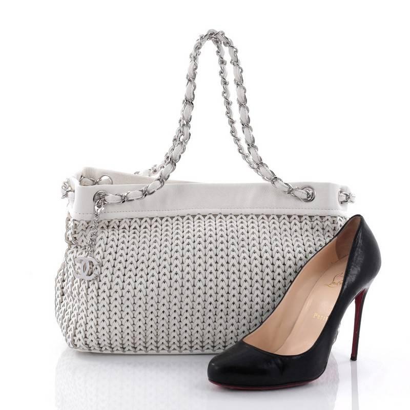 This authentic Chanel CC Charm Tote Woven Leather Medium showcases an elegant and timeless design made for Chanel lovers. Crafted in white woven leather, this tote features woven-in leather chain straps, white leather trims, CC silver charm,