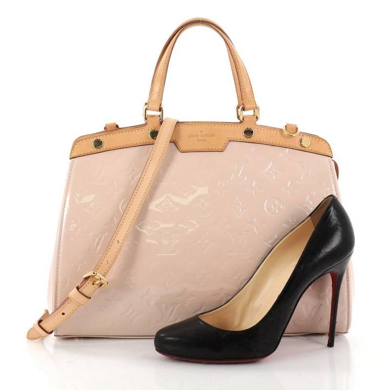 This authentic Louis Vuitton Brea Handbag Monogram Vernis MM is a staple for an everyday casual look. Crafted in light pink monogram vernis leather with cowhide leather trims, this structured yet feminine tote features dual flat handles, stand-out