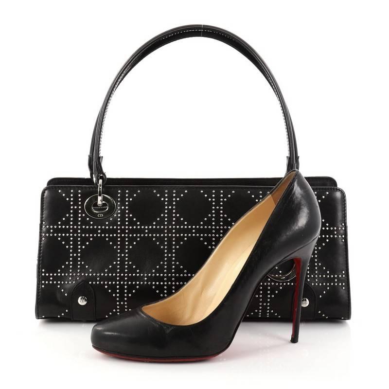 This authentic Christian Dior East West Lady Dior Handbag Cannage Studded Leather Small is a classic and chic bag ideal for your nights out. Crafted from black cannage studded leather, this luxurious handbag features dual flat leather handles with