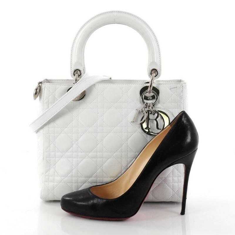 This authentic Christian Dior Lady Dior Handbag Cannage Quilt Lambskin Medium is an elegant classic bag that every fashionista needs in her wardrobe. Crafted from white lambskin leather in Dior's iconic cannage quilting, this boxy bag features short