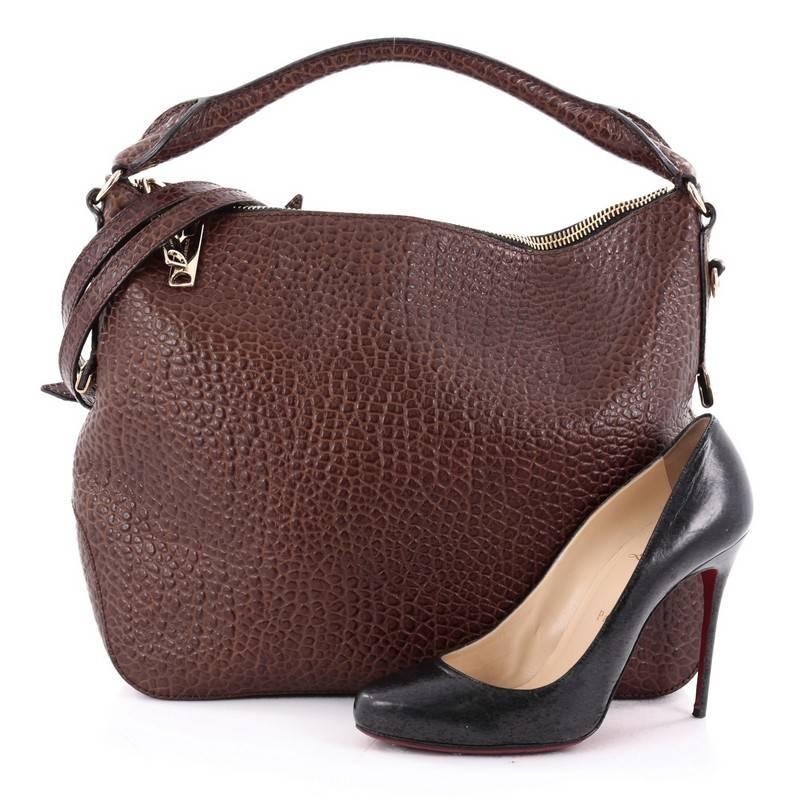 This authentic Burberry Ledbury Convertible Hobo Heritage Grained Leather Small is a timeless and refined bag that is something you will carry with you for years to come. Crafted from brown grained leather, this luxurious hobo features rolled