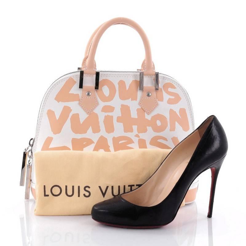 This authentic Louis Vuitton Alma Handbag Limited Edition Graffiti Leather MM designed by artist Stephen Sprouse balances sophisticated style with a playful twist. Crafted in a smooth white leather with beige graffiti prints, this handbag features