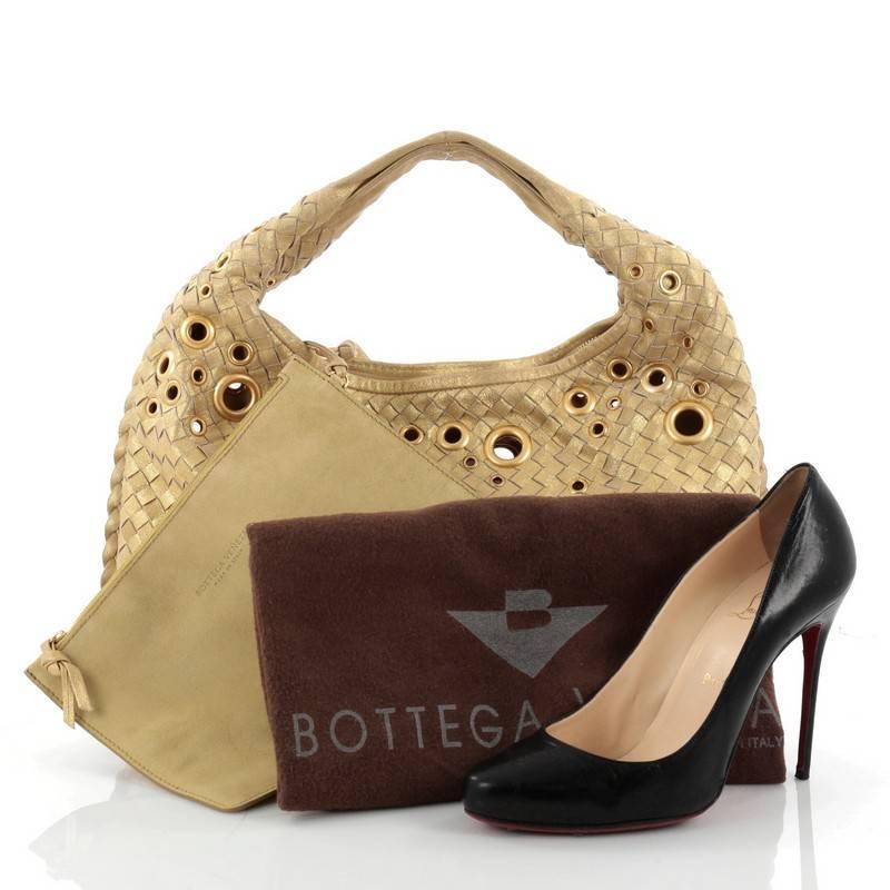 This authentic Bottega Veneta Veneta Hobo Intrecciato Leather with Grommet Detail Medium is a timelessly elegant bag with a casual silhouette. Excellently crafted from gold leather woven in Bottega Veneta's signature intrecciato method, this no-fuss