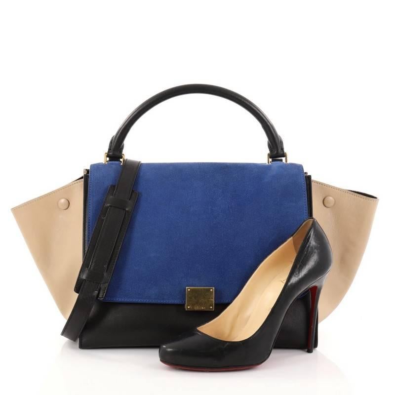 This authentic Celine Tricolor Trapeze Handbag Suede Medium is a modern minimalist design with a playful twist in an array of subdued colors. Crafted from blue suede and nude and black leather, this popular bag features gold-tone hardware accents,