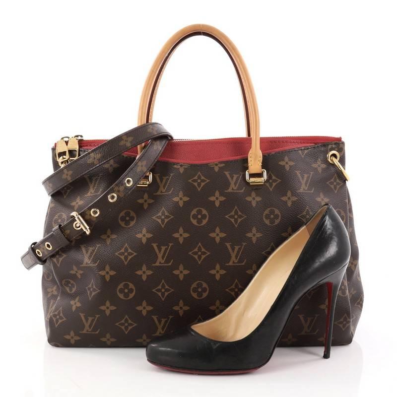 This authentic Louis Vuitton Pallas Tote Monogram Canvas is a mix of classic style with modern functionality. This structured satchel features the brand's signature monogram coated canvas with peeking red calfskin leather trims, dual-rolled handles,