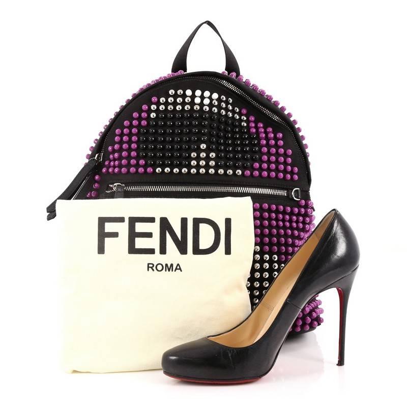 This authentic Fendi Karlito Backpack Studded Nylon is an eye catching, luxurious, playful style made for on-the-go fashionistas. Crafted from purple, black and white studded nylon, this backpack features adjustable canvas straps, exterior front zip