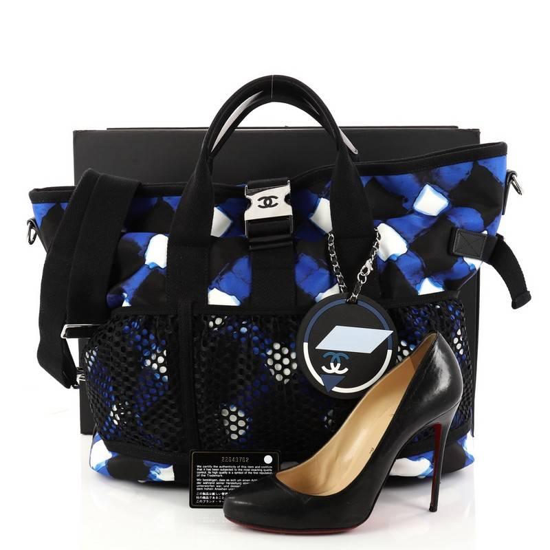 This authentic Chanel Airlines Mesh Tote Printed Nylon is a chic and sporty collector's bag that has a distinctive design perfect for on the go moments. Crafted in blue printed nylon with black mesh detailing, this stylish tote bag features dual