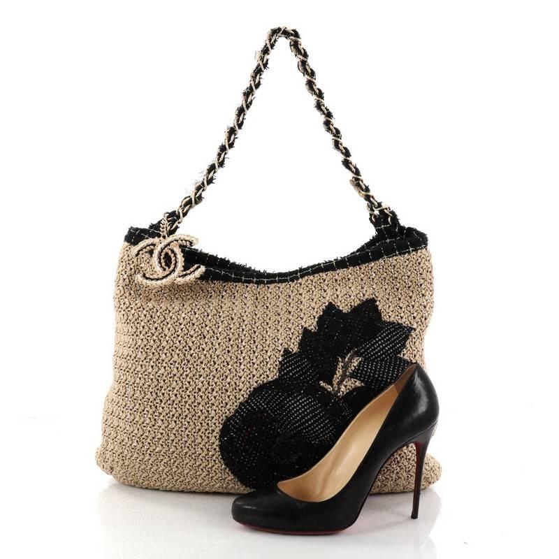 This authentic Chanel Coco Country Camellia Tote Woven Straw Large is from the brand's Spring/Summer 2010 collection, in which Karl Lagerfeld was inspired by the Parisian countryside and the bouquets of wheat that Coco Chanel kept around her