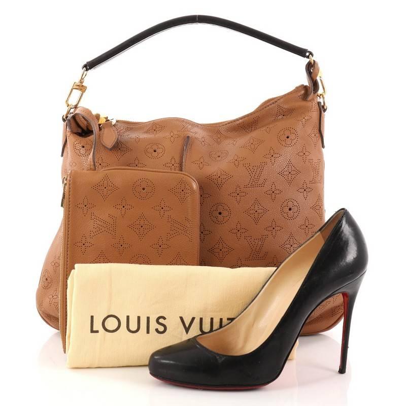 This authentic Louis Vuitton Selene Handbag Mahina Leather PM is a luxe and feminine design. Crafted in light brown monogram perforated mahina leather, this beautiful hobo features a single loop leather handle, detachable leather strap, pleated