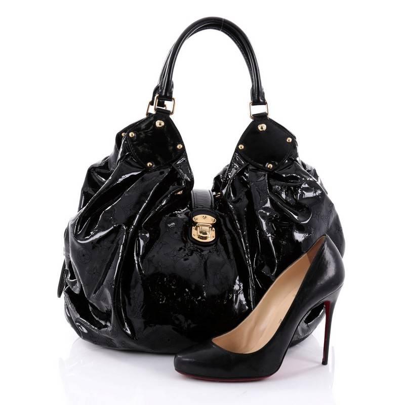 This authentic Louis Vuitton L Hobo Surya Leather is sleek and refined in design apt for the modern woman. Crafted in LV’s black patent leather, this oversized sun-inspired hobo features dual-rolled handles, buckle and stud details, protective base