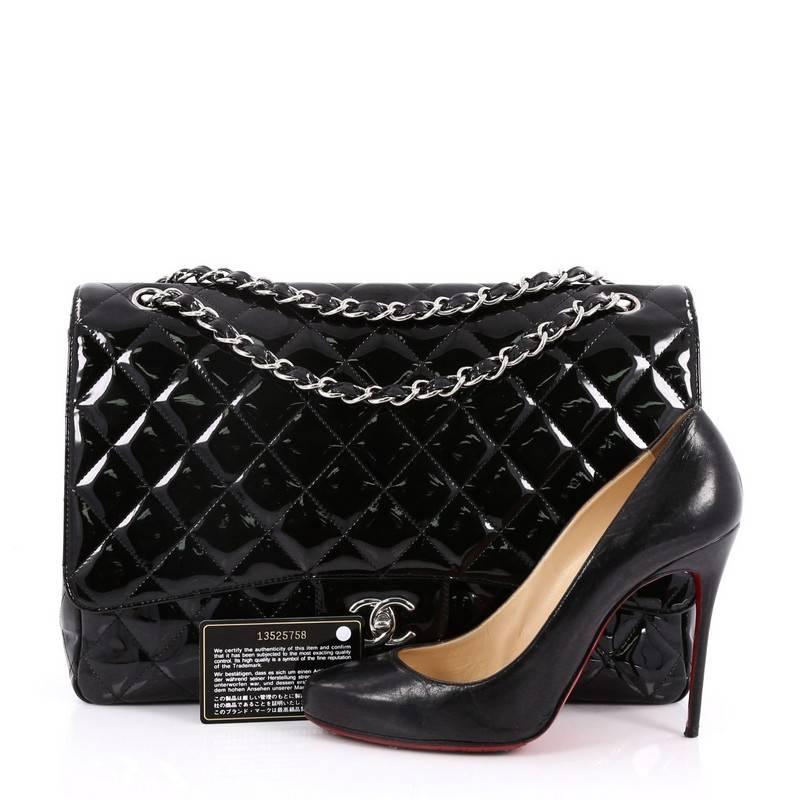 This authentic Chanel Classic Single Flap Bag Quilted Patent Maxi exudes a classic yet easy style made for the modern woman. Crafted from black patent leather, this elegant flap features Chanel's signature diamond quilted design, woven-in leather