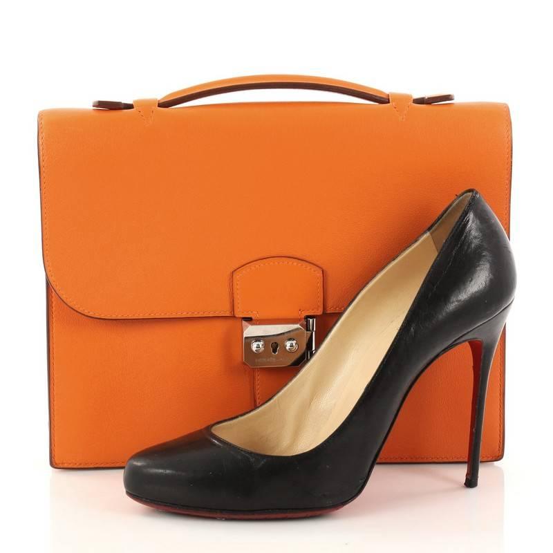 This authentic Hermes Sac a Depeche Handbag Swift 27 showcases a simple yet modern style perfect for everyday office use. Crafted from orange swift leather, this timeless briefcase features a flat top handle and palladium hardware accents. Its flip