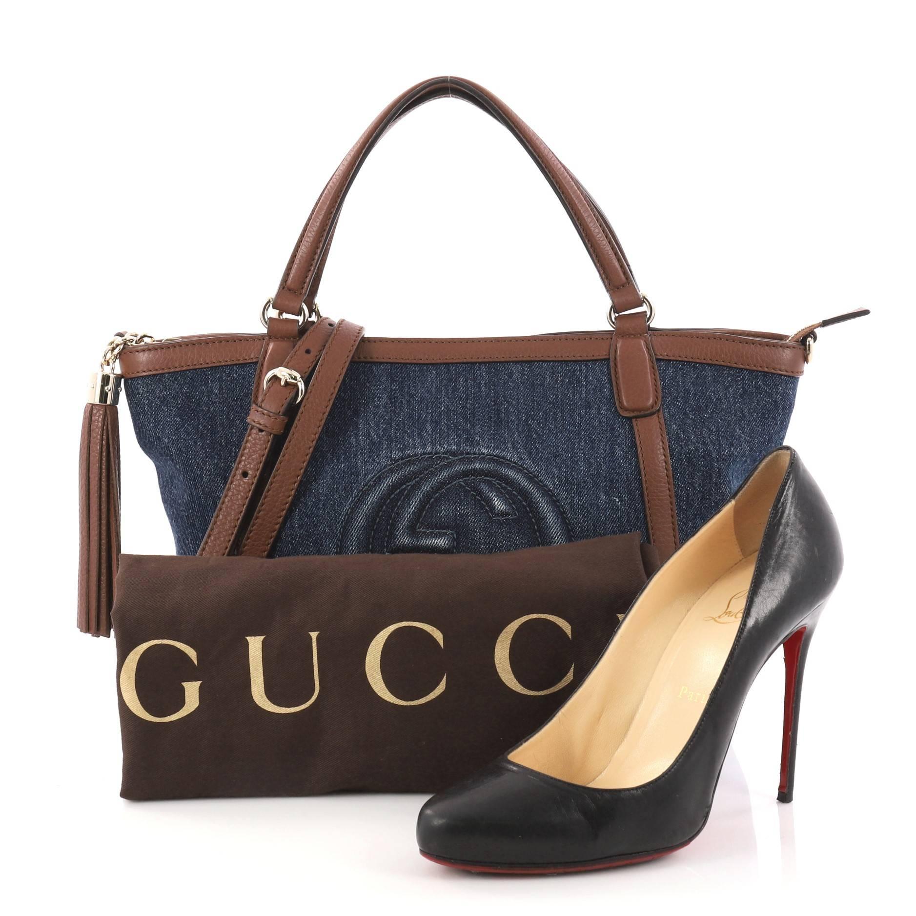 This authentic Gucci Soho Convertible Top Handle Bag Denim Small is a fresh, casual-chic tote made for everyday excursions. Crafted from navy denim with brown leather trims, this no-fuss tote features Gucci's signature interlocking GG logo stitched