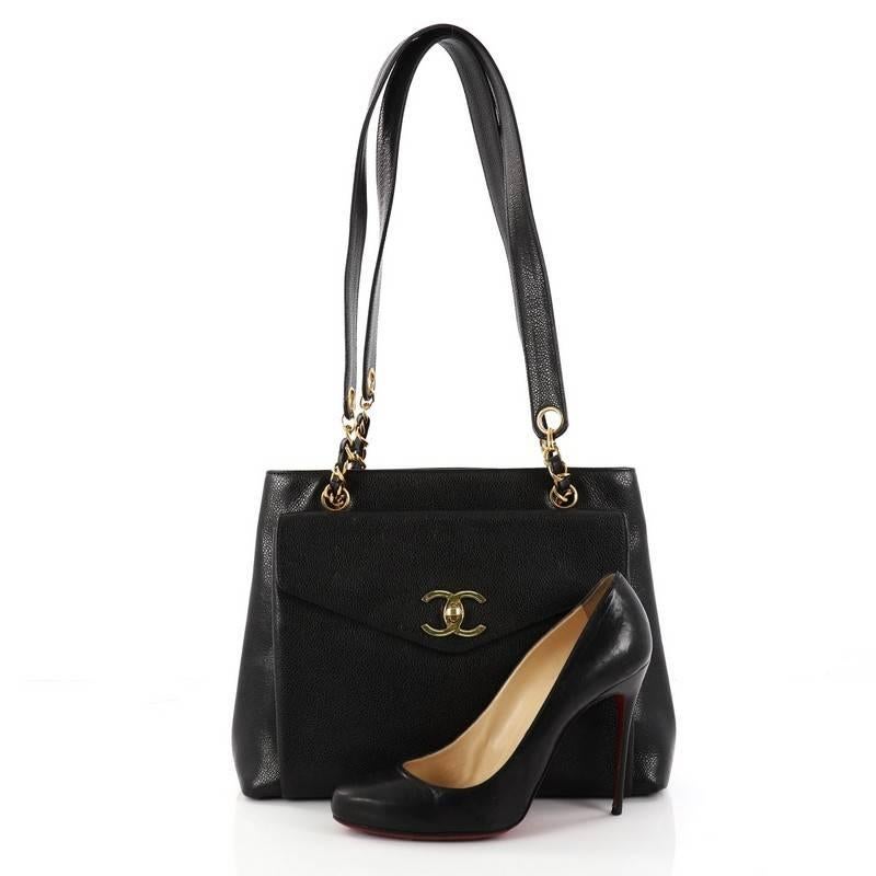 This authentic Chanel Vintage Front Pocket Tote Caviar Large is a timeless piece embodying Chanel's classic design. Crafted from black caviar leather, this classic tote features woven-in chain and leather straps, an envelope-style front pocket with