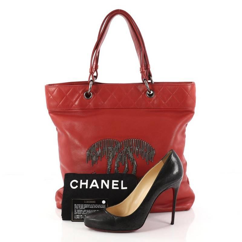 This authentic Chanel Rock and Cabaret Tote Lambskin is a hard-to-find limited edition collector's item mixing classic Chanel styling with cool-girl edge. Crafted in red lambskin leather, this runway-ready bag features aged silver dripping chain