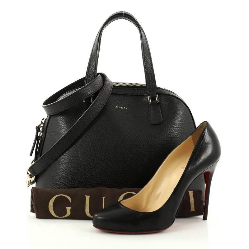 This authentic Gucci Lady Dollar Dome Satchel Leather Medium is sophisticated and minimalist in design ideal for everyday use. Crafted from black leather, this bag features dual-flat leather handles, Gucci stamp logo, protective feet, and gold-tone