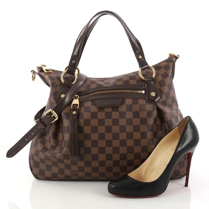 This authentic Louis Vuitton Evora Handbag Damier MM displays understated simplicity and elegance with versatile functionality made for the modern woman. Crafted from Louis Vuitton's popular damier ebene coated canvas, this everyday tote features