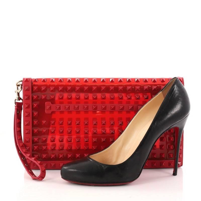 This authentic Valentino Rockstud Flap Clutch Studded PVC with Leather is a chic yet functional accessory perfect for on-the-go moments. Crafted from red studded PVC with red leather trims, this trendy clutch features a leather hand sling, studded