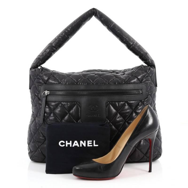 This authentic Chanel Coco Cocoon Hobo Quilted Nylon Medium is a highly sought after piece from Lagerfeld's fun and chic Coco Cocoon line. Crafted from black quilted nylon, this sporty-chic hobo features padded top handle, interlocking CC logo