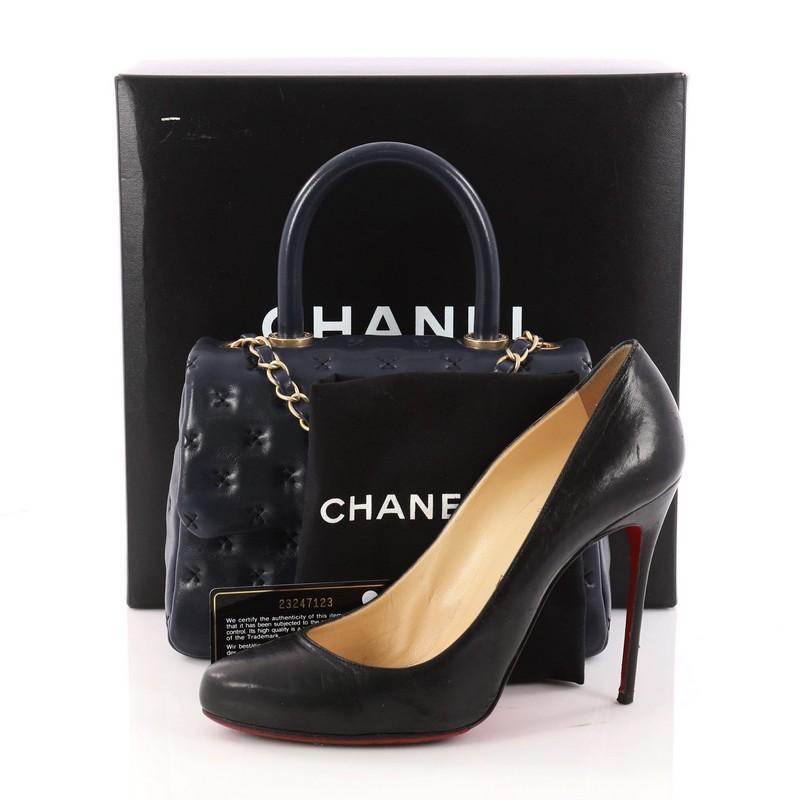 This authentic Chanel Paris-Rome Coco Top Handle Bag Cross Stitch Lambskin Small is a gorgeous bag that displays a timeless quality and style. Crafted in blue lambskin leather, this sleek bag features a rolled top handle, woven-in leather chain