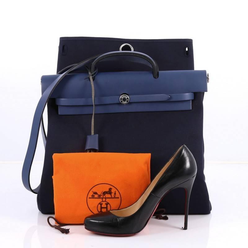 This authentic Hermes Herbag Toile and Leather MM is a fabulously functional Hermes set with two stylishly classic handbags fitting any mood. Constructed from Blue Saphir toile and leather, this functional bag showcases a leather top handle, a flap