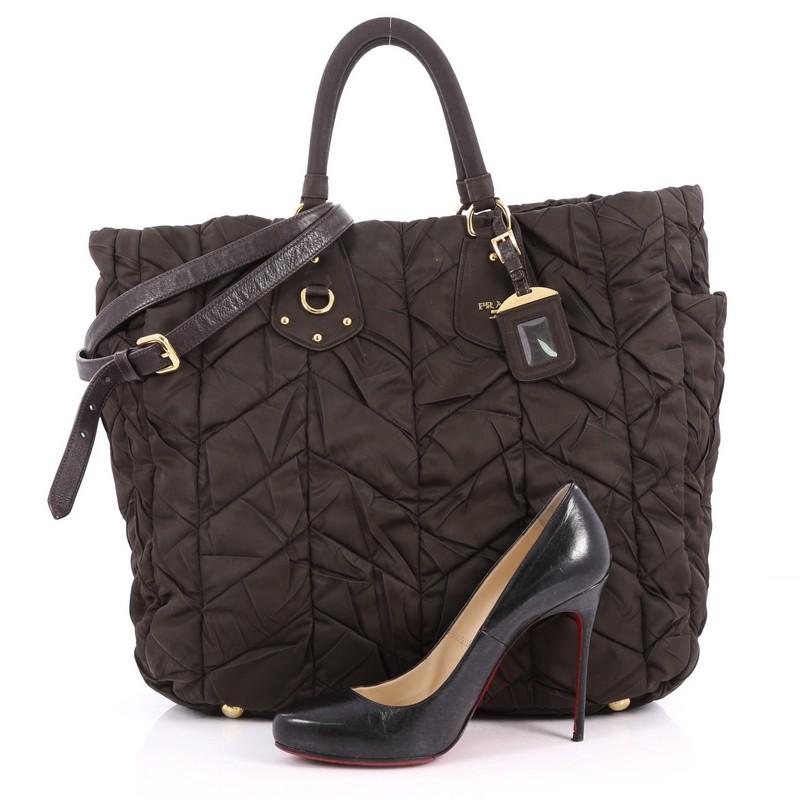 This authentic Prada Convertible Side Pocket Tote Chevron Tessuto Large is a simple stylish tote made for everyday use. Crafted from brown chevron quilted tessuto, this bag features dual-rolled handles, raised Prada logo, two exterior side pockets