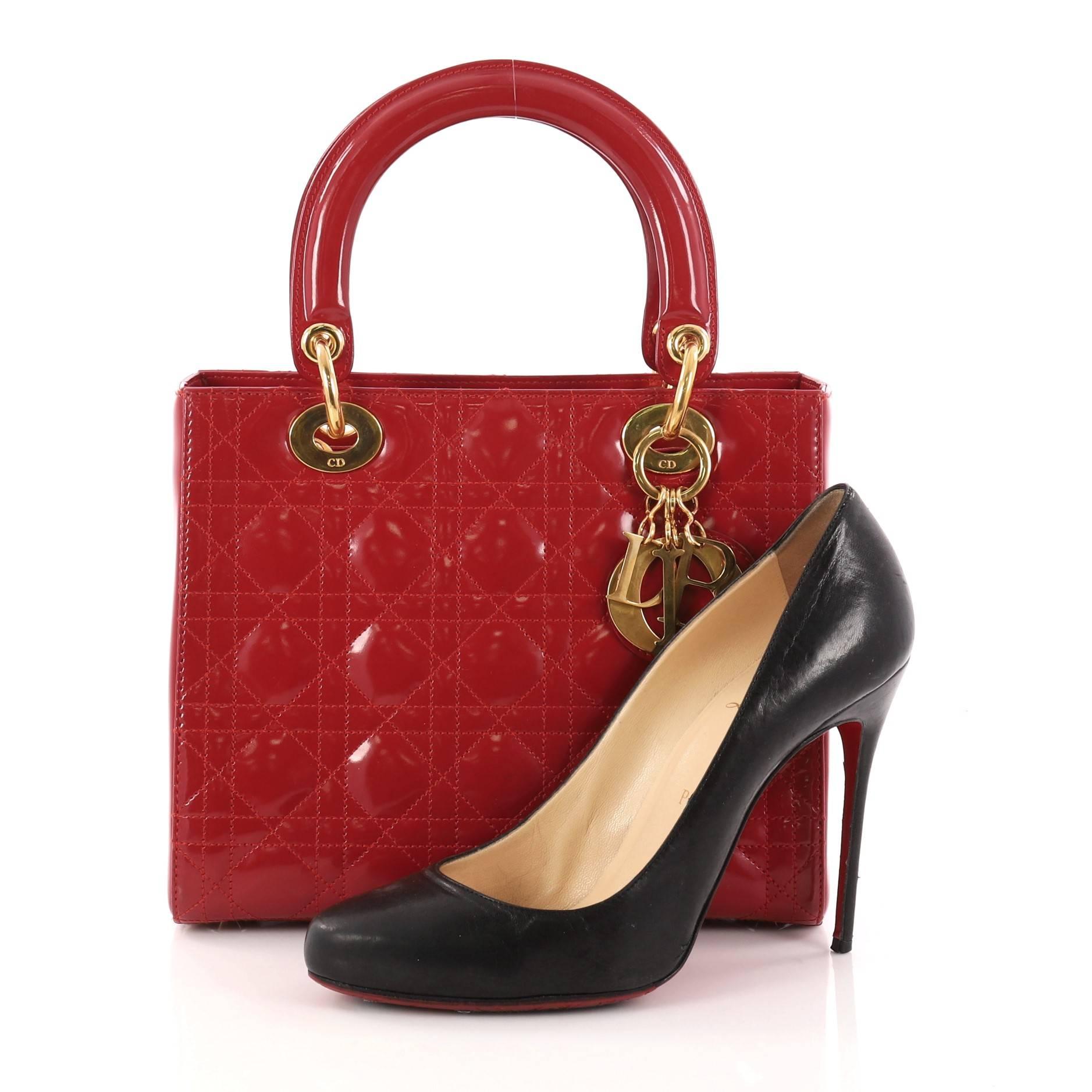This authentic Christian Dior Lady Dior Handbag Cannage Quilt Patent Medium is a classic staple that every fashionista needs in her wardrobe. Crafted from red patent leather in Dior's iconic cannage quilting, this boxy bag features dual-rolled