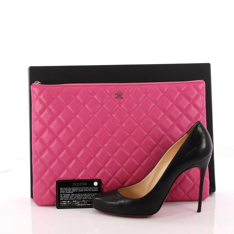 This authentic Chanel O Case Clutch Quilted Caviar Large adds a touch of elegant to your everyday outfits. Crafted from pink quilted caviar leather, this chic clutch features a tiny CC logo on the front and silver-tone hardware accents. Its zip
