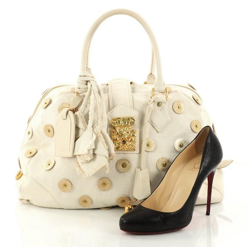 This authentic Louis Vuitton Polka Dot Panama Bowly Handbag Embellished Canvas is a limited edition bag from the brands' 2007 Collection. Crafted from beige canvas, this stylish bag features dual-rolled canvas handles, logo printed disc